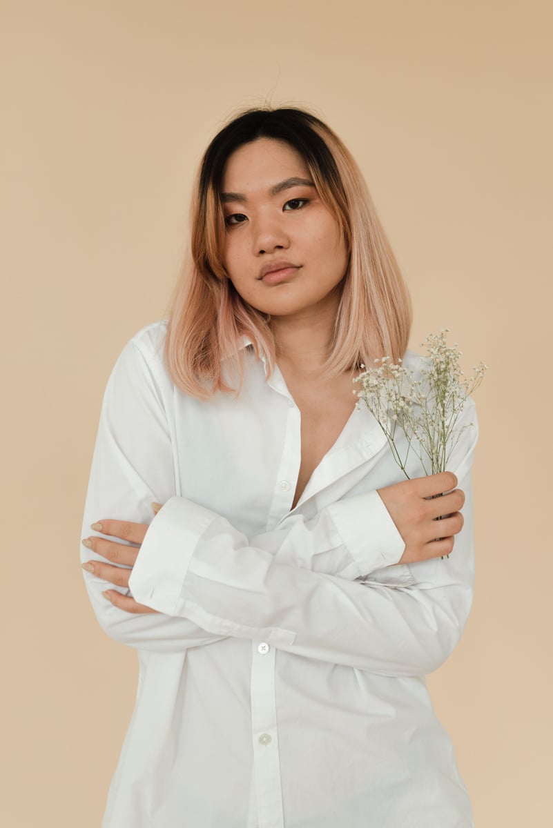 A Pretty Woman in White Long Sleeves Holding Flowers